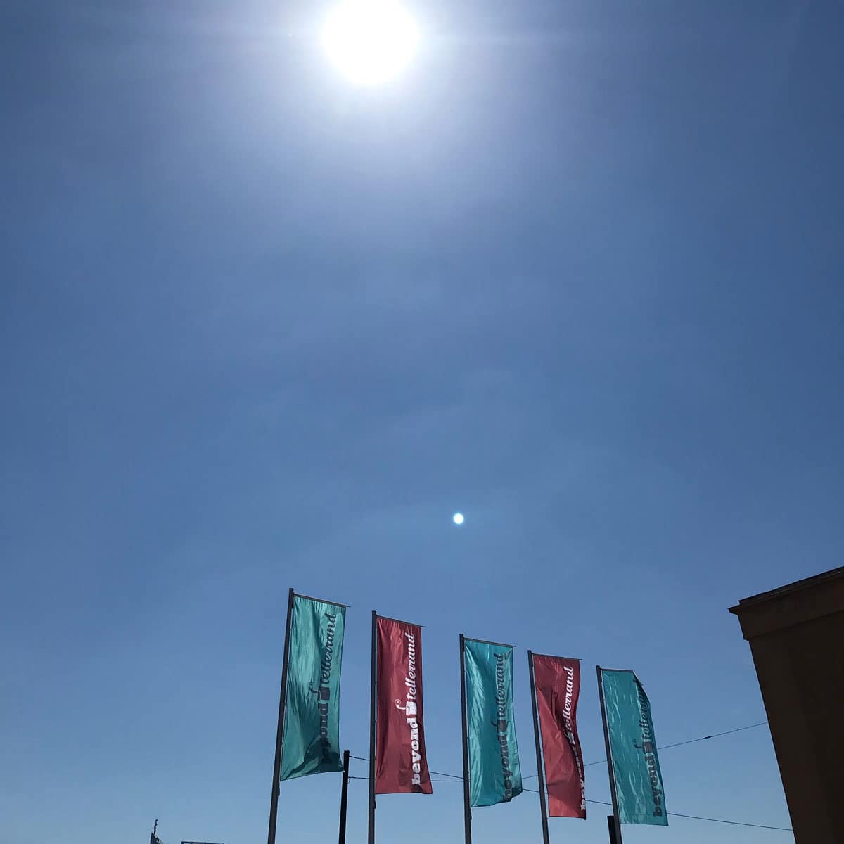 A bright blue Düsseldorf sky with five Beyond Tellerrand flags in the foreground