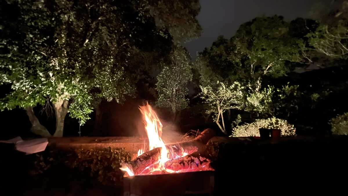 Small bonfire burning on the terrace above a garden 